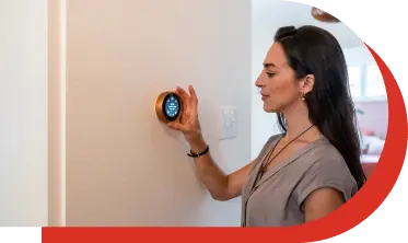 A woman is adjusting the digital thermostat operating on the internet.